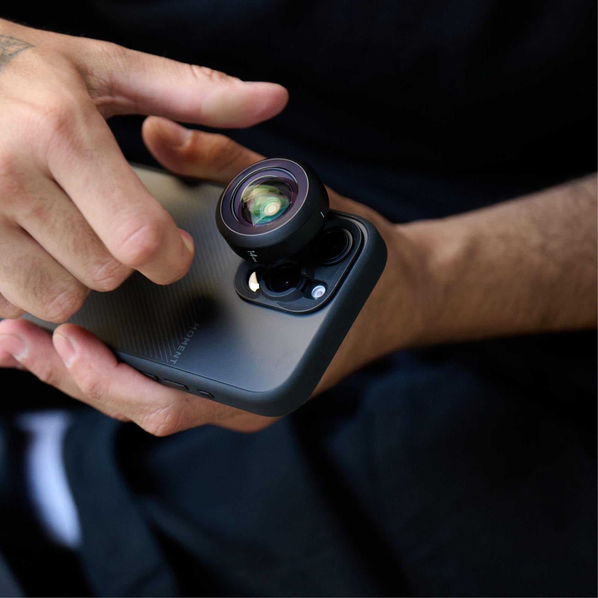 Hand turning the lens on an iPhone to create awesome pictures and videos