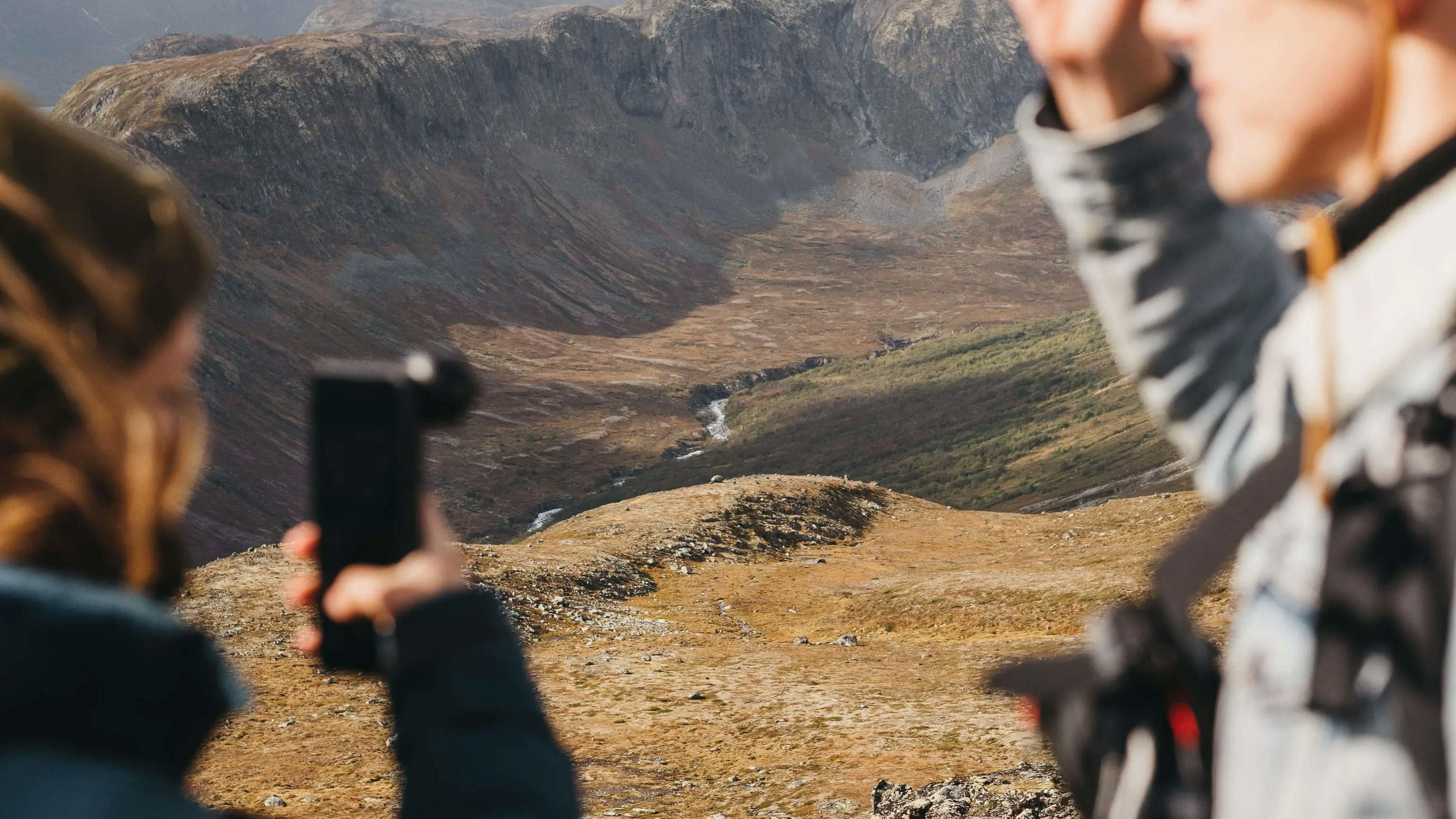 Photogaraphers using moment gear to capture a photo of a mountain range