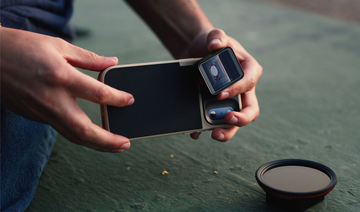 hands installing the anamorphic lenses with filters on iphones 